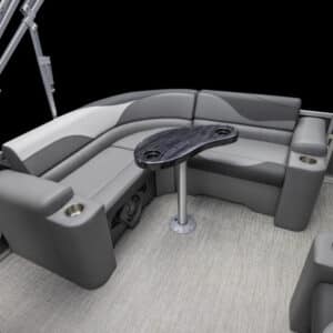 A view of a LSZ Elite's stylish seating area featuring gray cushioned seats with a U-shaped configuration and a sleek, dark oval table in the center. The flooring is a light-colored, textured material, and there are multiple cupholders integrated into the seats.