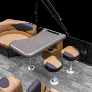 The image shows the interior of a LSZ Entertainer with a granite-like table and brown cushioned seating. The setup includes a curved bench, three stools, and wood-like flooring, all in a color scheme of brown and black. The area appears clean and is well-appointed.