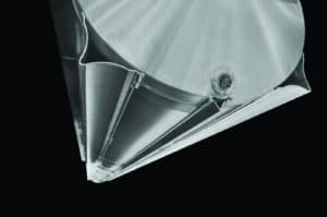 Close-up of a modern metallic architectural detail featuring sleek lines and geometric shapes against a black background. The surface has a brushed finish, and there is a screw visible near the center. The overall design is minimalistic and contemporary.