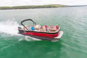 Seven people sitting comfortable on a large red pontoon boat.