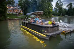 Family in a yellow-lit pontoon boat at night.