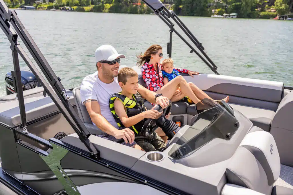 Family happily riding in an Avalon Pontoon Boat in the ocean.