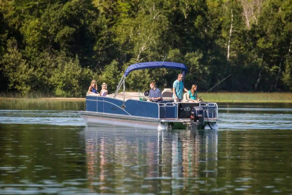 Family fishing in a pontoon boat in the middle of a lake.
