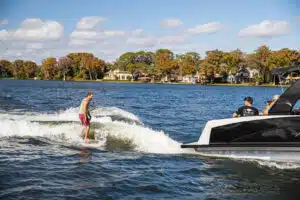 Surfboarder on back of Avalon Waketoon Pontoon Boat