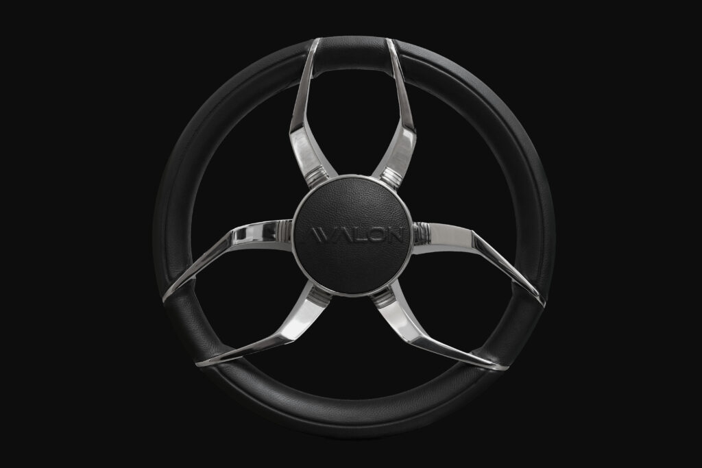A modern black and silver steering wheel with five sleek, metallic spokes and "AVALON" written at the center, set against a plain black background.
