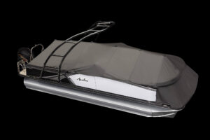 A sleek, modern pontoon boat covered with a protective gray canvas. The boat features a metallic silver and white exterior, a sturdy black frame with a ladder on the side, and an outboard motor at the rear. The background is completely black, highlighting the boat.