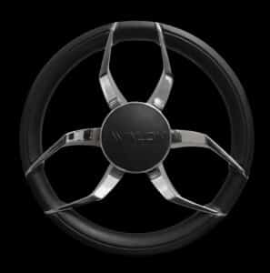 A black and silver steering wheel on a black background. Four metallic spokes, each connecting to an outer rim covered in a black textured material. The central hub is embossed with the word "VALON". The design is modern with a sleek appearance.