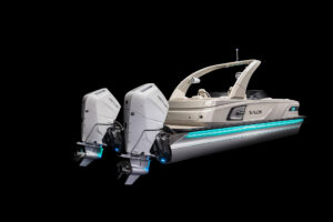 A luxury speedboat with dual outboard engines, sleek white design, and blue accent lights is shown against a black background. The boat features an elegant arch and a spacious deck area labeled "Avalon.