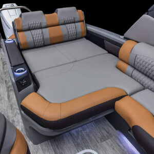 Image of a luxurious boat interior featuring a spacious Excalibur LTD Versatile Rear Bench Windshield with adjustable backrests. The seatbacks are equipped with electronic controls and built-in cup holders, all on a sleek, wood-patterned floor with ambient lighting.