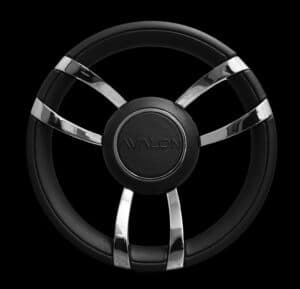 A stylish black steering wheel with four polished silver accents intersecting at the center. The central hub features the brand name "VALON" prominently embossed. The background is entirely black, emphasizing the sleek design of the steering wheel.