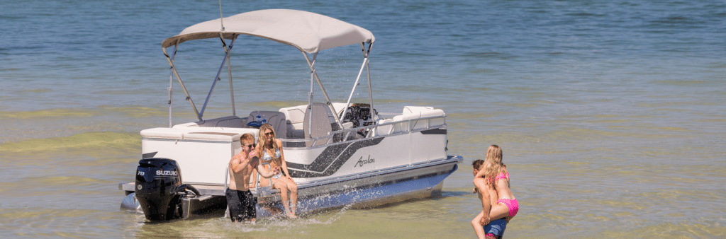 A group of friends playing in the ocean, with the Avalon Boat parked