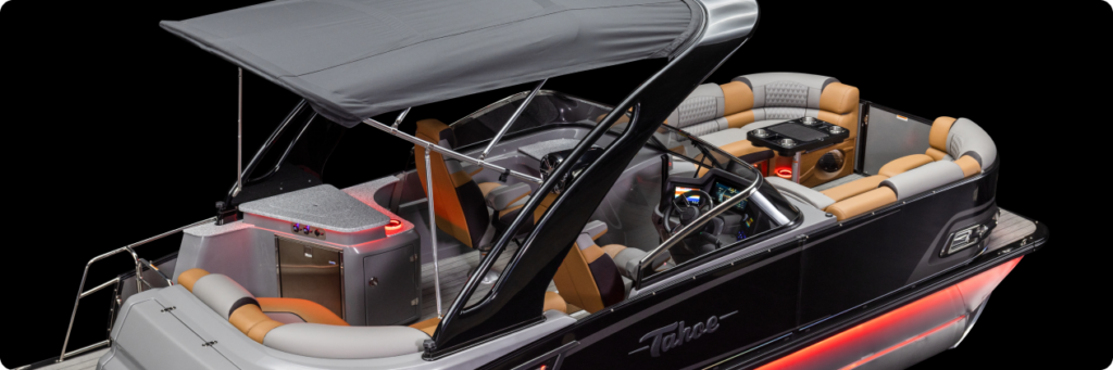 Image of a luxury pontoon boat with cushioned seating, a spacious deck area, and a canopy providing shade. The interior features a bar with stools, a steering console with multiple controls, and accent lighting that adds a stylish touch. This model integrates the elegance of small pontoons.